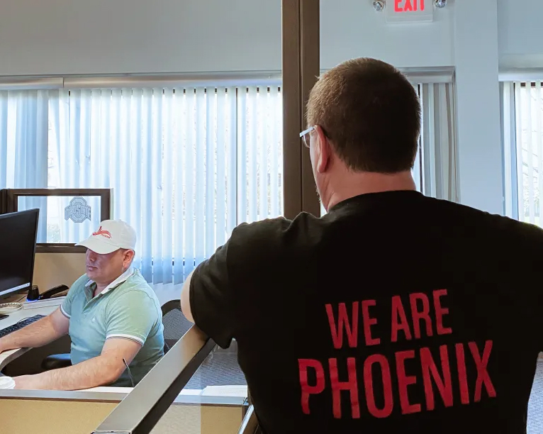 trucker wearing black "we are Phoenix" shirt in office